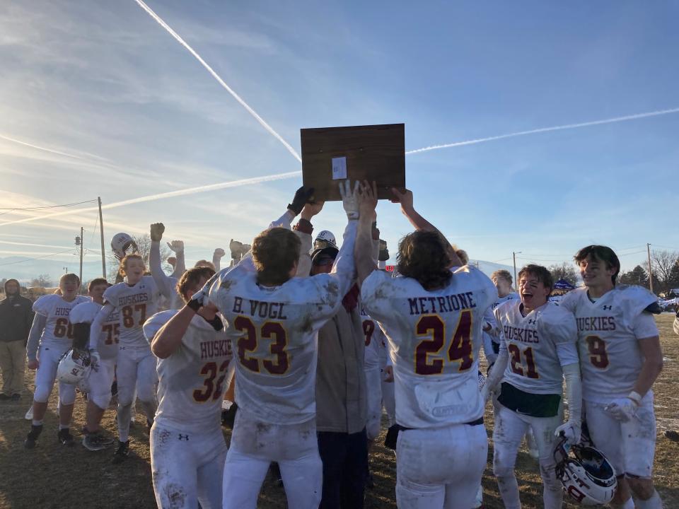 The Belt football team hoists the Eight-Man state championship trophy after defeating St. Ignatius 52-24 on Saturday at Mission High School.