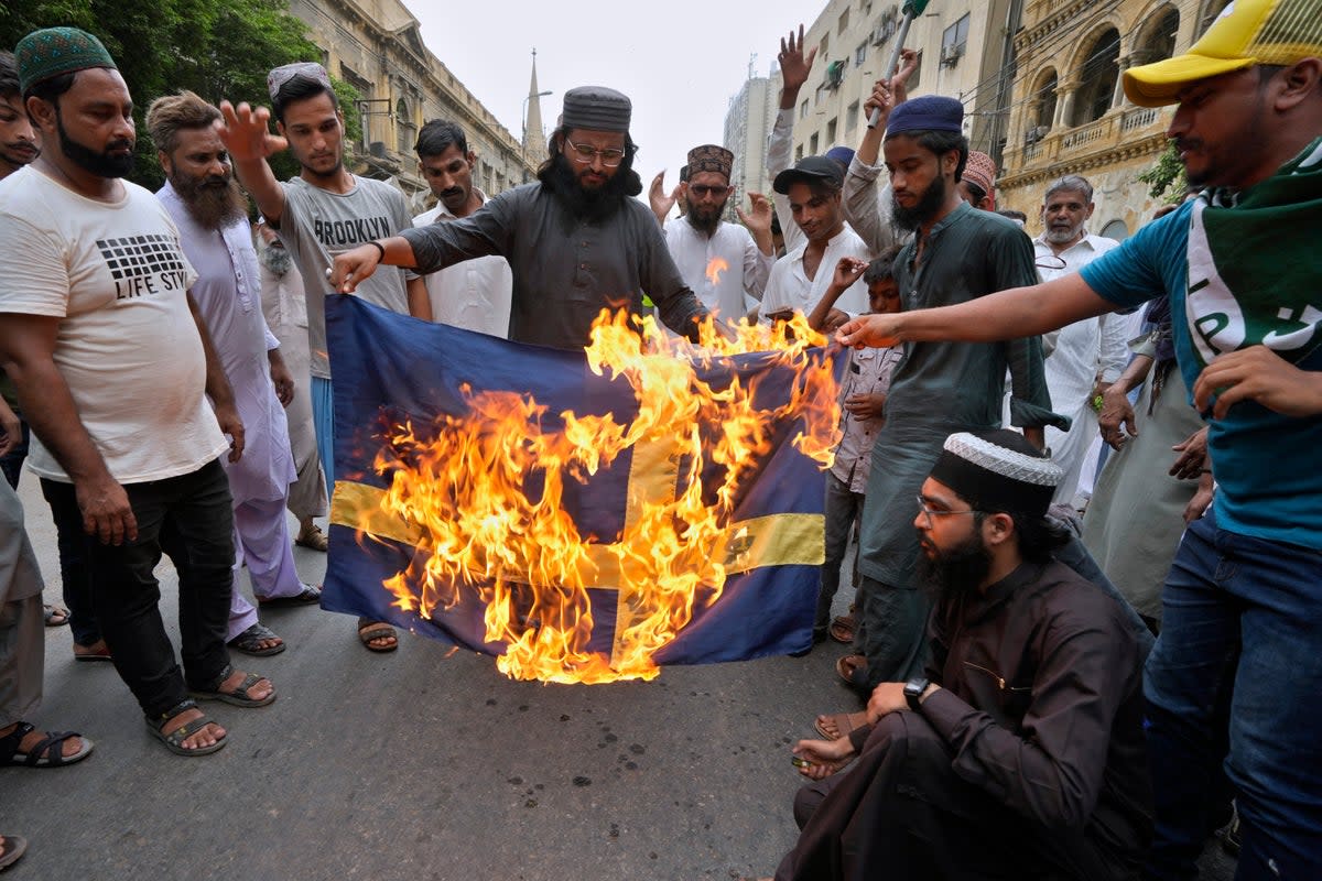 Supporters of a radical Islamist party ‘Tehreek-e-Labbaik Pakistan’ burn the representation of Swedish flag (AP)