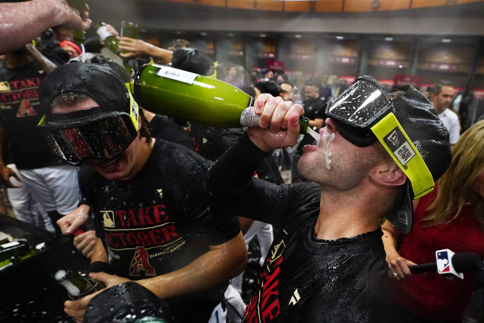 Arizona Diamondbacks players celebrate in the locker room after clinching a Wild Card spot in the MLB playoffs after a baseball game against the Houston Astros, Saturday, Sept. 30, 2023, in Phoenix. The Astros won 1-0. (AP Photo/Ross D. Franklin)