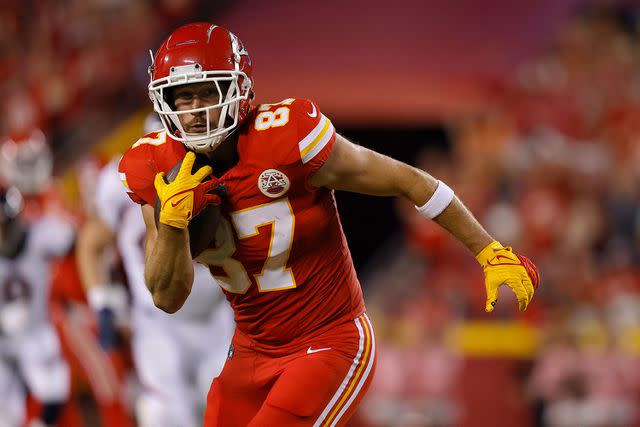 <p>David Eulitt/Getty</p> Travis Kelce #87 of the Kansas City Chiefs carries the ball against the Denver Broncos during the second quarter at GEHA Field at Arrowhead Stadium on October 12, 2023 in Kansas City, Missouri.