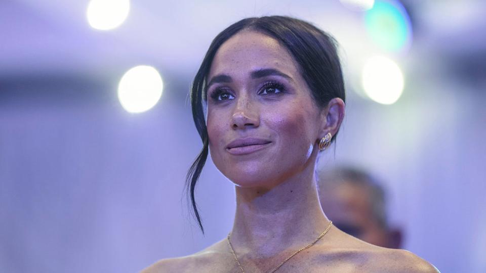 A close-up of Meghan Markle wearing a gold chain necklace.