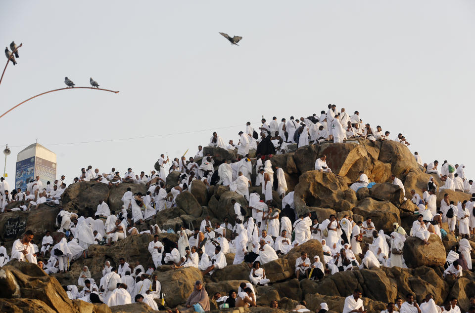 Muslim pilgrims pray on a rocky hill known as Mountain of Mercy, on the Plain of Arafat, during the annual hajj pilgrimage, near the holy city of Mecca, Saudi Arabia, Saturday, Aug. 10, 2019. More than 2 million pilgrims were gathered to perform initial rites of the hajj, an Islamic pilgrimage that takes the faithful along a path traversed by the Prophet Muhammad some 1,400 years ago. (AP Photo/Amr Nabil)