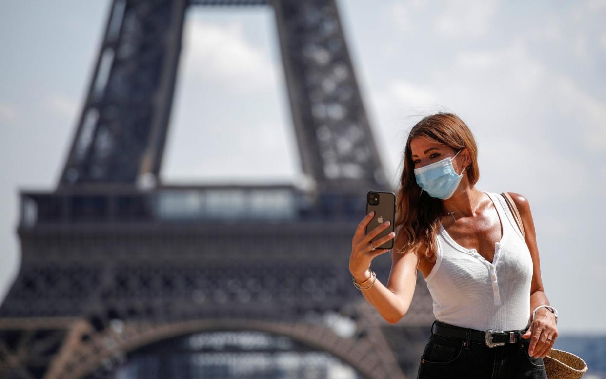 A woman wears a protective face mask - BENOIT TESSIER/REUTERS