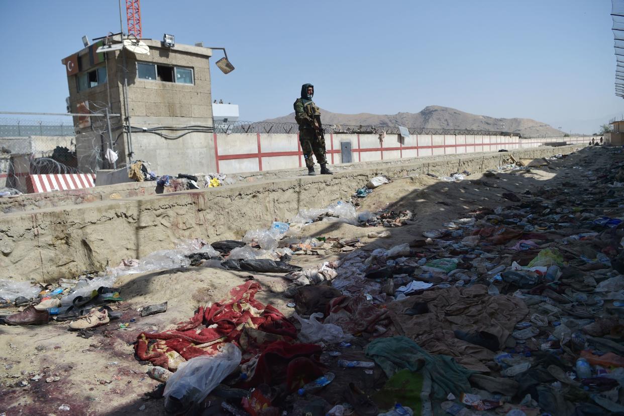 A Taliban fighter stands guard at the site of the August 26 twin suicide bombs, which killed scores of people including 13 US troops, at Kabul airport on August 27, 2021. (Photo by WAKIL KOHSAR / AFP) (Photo by WAKIL KOHSAR/AFP via Getty Images)