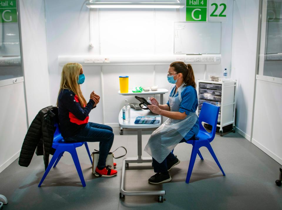 Immunisation Nurse Debbie Briody (R) fills in forms prior to administering the Pfizer/BioNtech Covid-19 vaccine to Staff Nurse Amanda Thompson at the NHS Louisa Jordan temporary hospital at the SEC Campus in Glasgow (AFP via Getty Images)