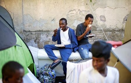 Migrants eat after getting food from volunteers at a makeshift camp in Via Cupa (Gloomy Street) in downtown Rome, Italy, August 1, 2016. REUTERS/Max Rossi/File Photo