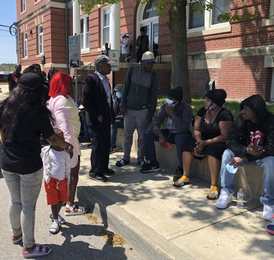 Asylum seekers waited to be helped outside Sanford City Hall in Sanford, Maine, on May 8, 2023.