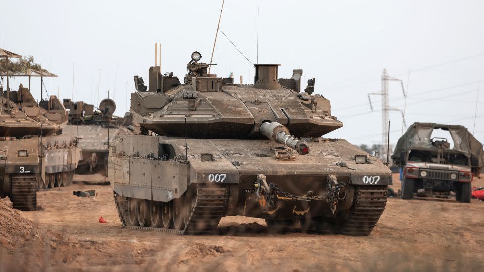 An Israeli tank and military vehicles are seen near Israel's border with the Gaza Strip, in Israel. - Violeta Santos Moura/Reuters