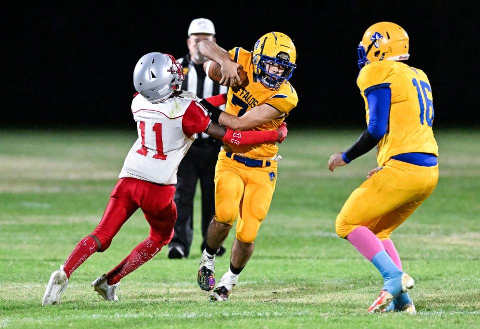 Alpaugh quarterback Jesse Alcazar tries to evade Mojave's Ricky Wilson in an 8-man high school football game on Friday, September 15, 2023. Thanks to new lighting it was the first night game at home since the school began 117 years ago.