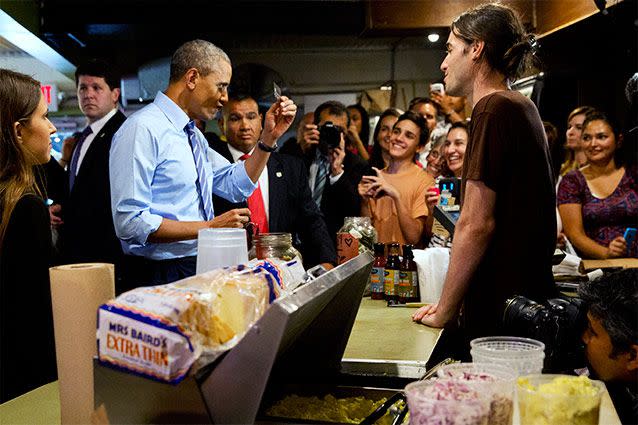 President Barack Obama scrutinises his credit card as he jokes with the waiting staff while ordering barbecued food at Franklin Barbecue in Austin, Texas. Source: AP Photo