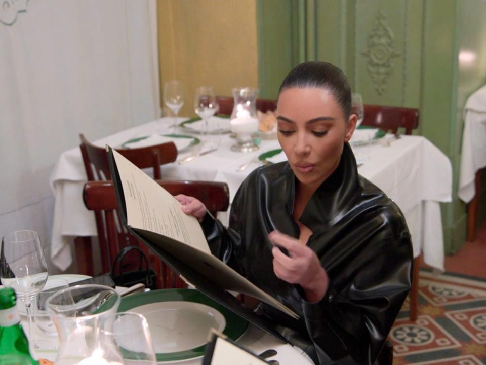 Kim Kardashian looking at a menu.