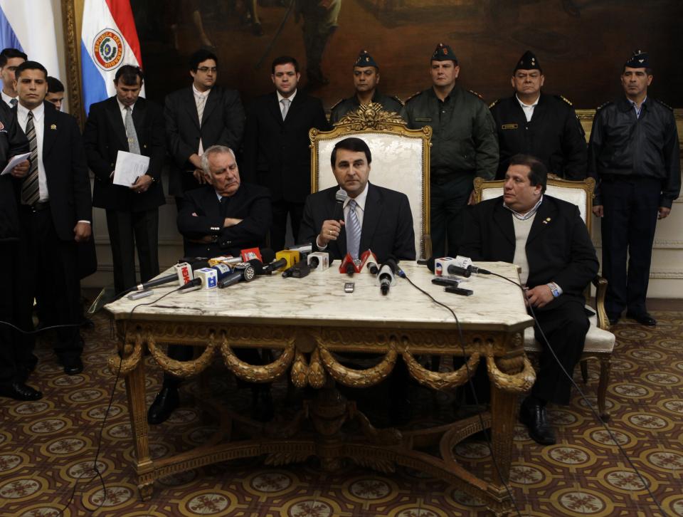 Paraguay's new President Federico Franco, sitting center, gives a news conference at the presidential palace in Asuncion, Paraguay, Saturday, June 23, 2012. Paraguay's newly sworn in president is promising to honor foreign commitments and reach out to Latin American leaders after the Senate removed President Fernando Lugo from office in a rapid impeachment trial on Friday. (AP Photo/Jorge Saenz)
