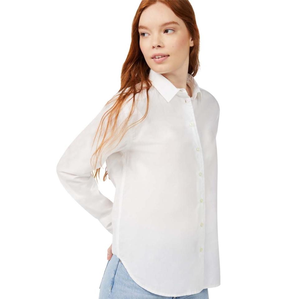 woman wearing white button down top and blue jeans