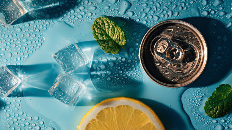 Can with ice and lemon on blue surface