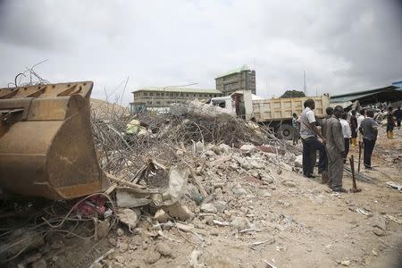 Rescue workers stand by an excavator at the site of a collapsed building at the Synagogue Church of All Nations in the Ikotun-Egbe neighbourhood of Nigeria's commercial capital Lagos, September 17, 2014. REUTERS/Akintunde Akinleye