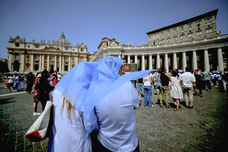 Dos personas se protegen del sol mientras siguen el rezo del ángelus por el papa Francisco en la plaza de San Pedro, un caluroso 21 de julio en 2024 en el Vaticano (Filippo Monteforte)