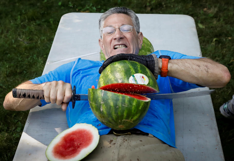 Ashrita Furman, who holds more Guinness World Records than anyone, attempts to set a new record for slicing the most watermelons in half on his own stomach in one minute in New York City, U.S., July 17, 2018. REUTERS/Brendan McDermid      TPX IMAGES OF THE DAY