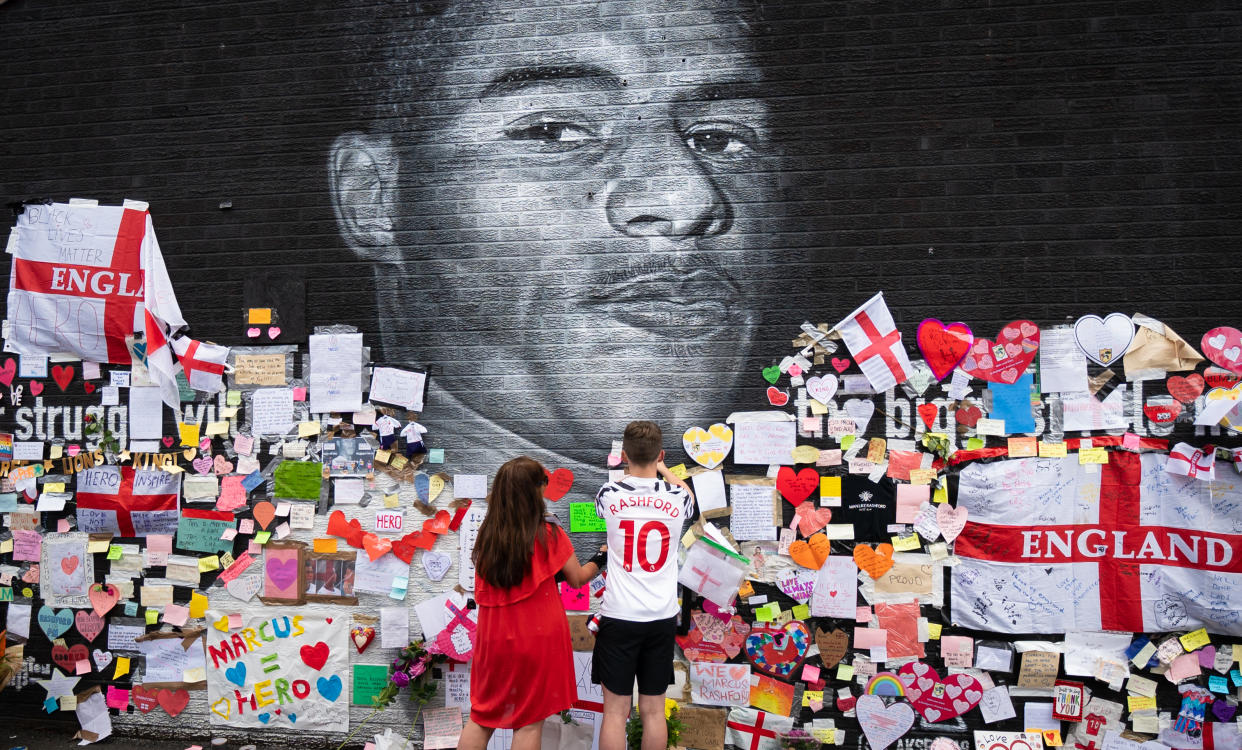 Mackenzie Robertson and his mother Sally Coles-Robertson put up a message on the mural of Manchester United striker and England player Marcus Rashford on the wall of the Coffee House Cafe on Copson Street, Withington. The mural appeared vandalised on Monday after the England football team lost the UEFA Euro 2021 final. Picture date: Tuesday July 13, 2021. Photo credit should read: Danny Lawson/PA Wire