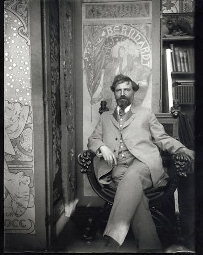 Self-portrait with posters for Sarah Bernhardt at Mucha’s studio in rue du Val-de-Grâce, Paris, c1901 © Mucha Trust 2024.