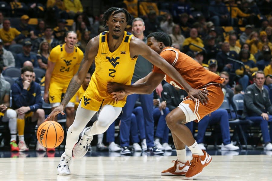 West Virginia guard Kobe Johnson (2) is defended by Texas guard Max Abmas, right, during the second half of an NCAA college basketball game on Saturday, Jan. 13, 2024, in Morgantown, W.Va. (AP Photo/Kathleen Batten)