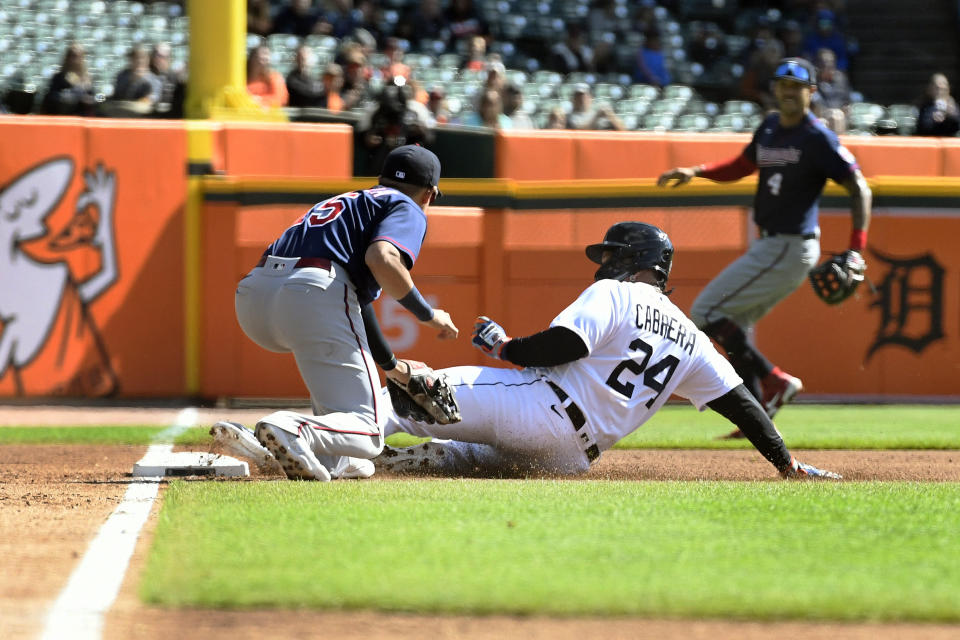 Detroit Tigers designated hitter Miguel Cabrera, right, slides into third base past the reach of Minnesota Twins third baseman Gio Urshela after a wild pitch by starting pitcher Simeon Woods Richardson during the first inning of a baseball game, Sunday, Oct. 2, 2022, in Detroit. (AP Photo/Jose Juarez)