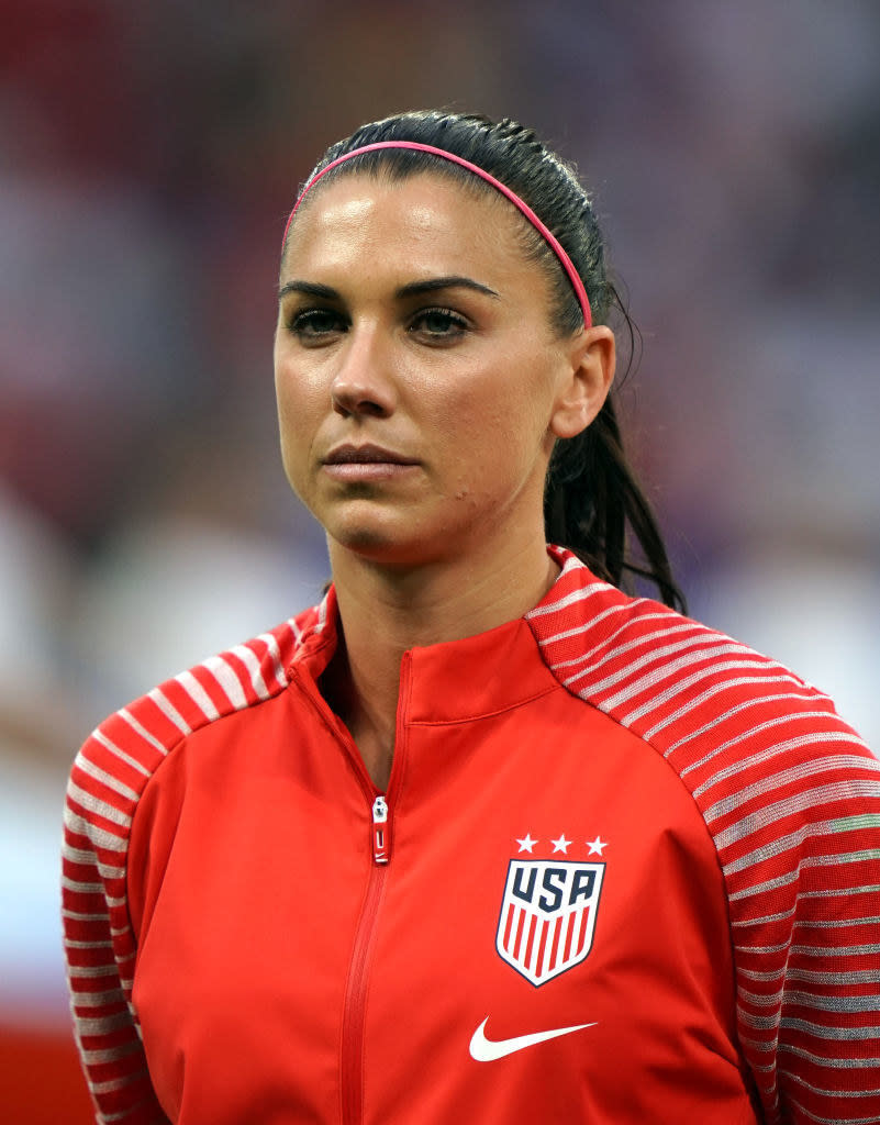 Alex Morgan stands on a soccer field before a game