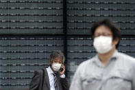 A man stands in front of a blank electronic stock board supposedly showing Japan's Nikkei 225 index at a securities firm in Tokyo Thursday, Oct. 1, 2020. Trading on the Tokyo Stock Exchange was suspended Thursday because of a problem in the system for relaying market information. Most other Asian markets were closed for national holidays. (AP Photo/Eugene Hoshiko)