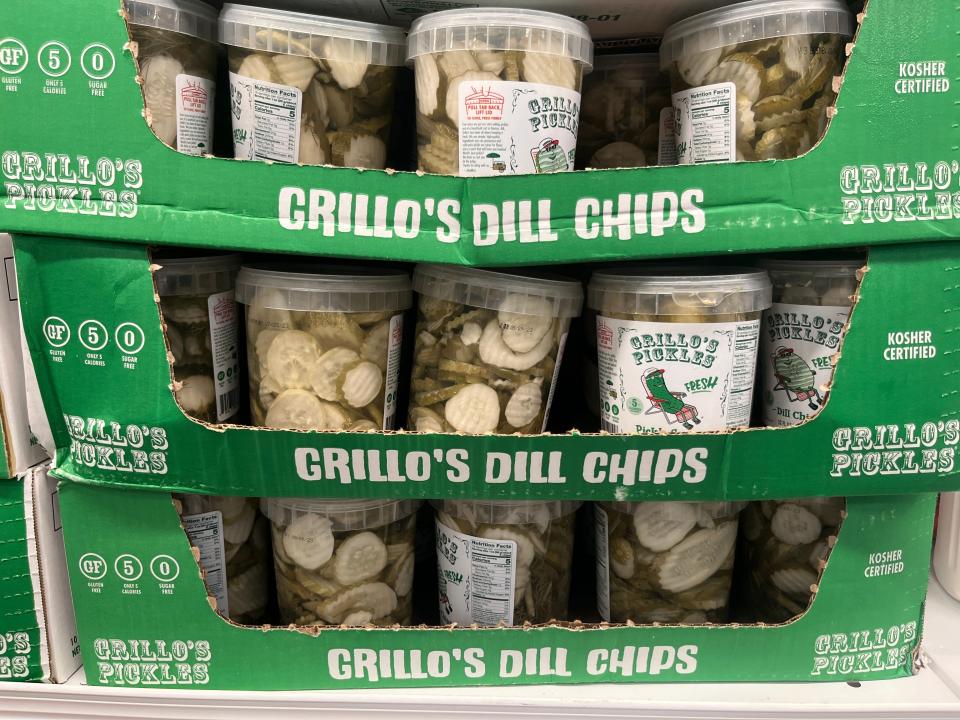 Grillo's Dill Chips cardboard displays with containers of pickles stacked on top of them