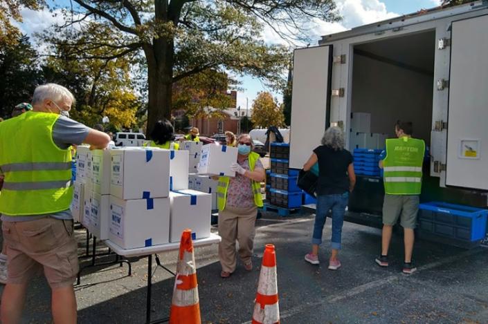 Volunteers of the Bethesda Chevy-Chase Charity organization distribute food packs to people in need in Bethesda, a relatively wealthy suburb of Washington on October 23, 2020