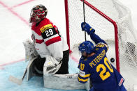 Sweden's Andre Petersson, right, celebrates after Par Lindholm scored the opening goal past Austria's goalie Bernhard Starkbaum during the group A match between Sweden and Austria at the ice hockey world championship in Tampere, Finland, Sunday, May 14, 2023. (AP Photo/Pavel Golovkin)