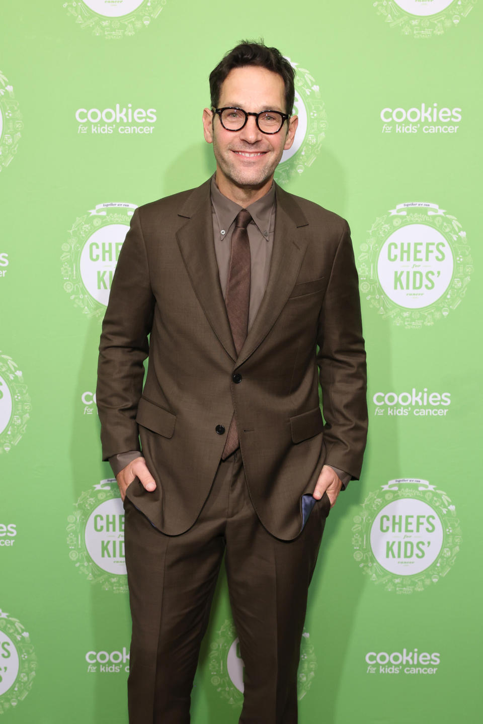 Close-up of Paul smiling in a suit and tie at a media event