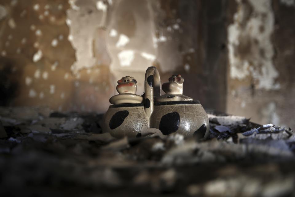 In this Friday, July 27, 2018 photo, a sugar and coffee bowl in the burnt kitchen of a damaged house in Mati, east of Athens. More than 86 people were either killed by the flames or drowned on Monday's wildfire as they tried to flee the fire into the nearby sea, waiting for hours in the water for rescue from local fishermen and private boat owners who saved many. (AP Photo/Thanassis Stavrakis)