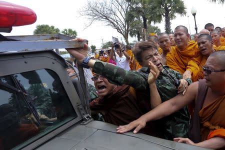 Buddhist monks scuffle with a soldier during a protest against state interference in religious affairs near a temple in Nakhon Pathom province on the outskirts of Bangkok, Thailand, February 15, 2016. REUTERS/Dailynews