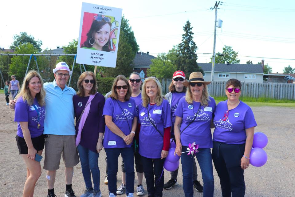 Jennifer Kelly's friends and family pose for a group photo at Ben R. McMullin Public School during a community walk organized in her memory.