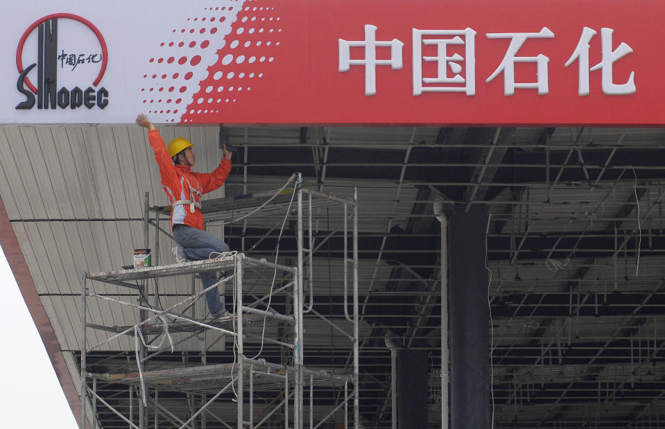 FILE - A Chinese worker labors on a Sinopec sign board at a gas station in Huai'an, eastern China's Jiangsu province on June 19, 2008. Chinese petroleum giant Sinopec signed an agreement with Sri Lanka on Monday, May 22, 2023, to enter the South Asian island country's retail fuel market as it struggles to resolve a worsening energy crisis amid an unprecedented economic upheaval.(AP Photo, File)