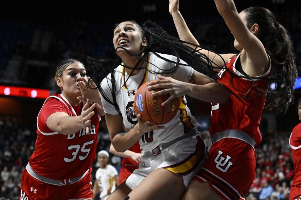 South Carolina center Kamilla Cardoso, center, looks to shoot as Utah forwards Alissa Pili, left, and Jenna Johnson, right, defend in the second half of an NCAA college basketball game, Sunday, Dec. 10, 2023, in Uncasville, Conn. | Jessica Hill, Associated Press