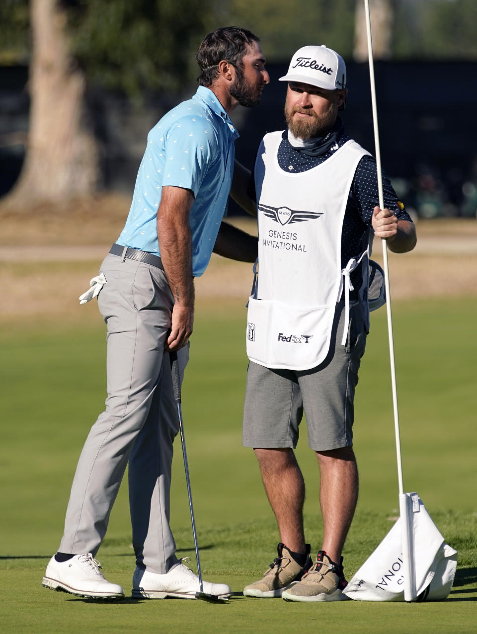 Max Homa, left, hugs his caddie on the 14th green after defeating Tony Finau in a two-hole playoff to win the Genesis Invitational golf tournament at Riviera Country Club, Sunday, Feb. 21, 2021, in the Pacific Palisades area of Los Angeles. (AP Photo/Ryan Kang)