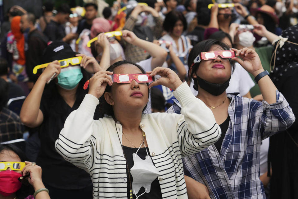 People wear protective glasses to watch a solar eclipse in Jakarta, Indonesia, on April 20. (Tatan Syuflana / AP file)