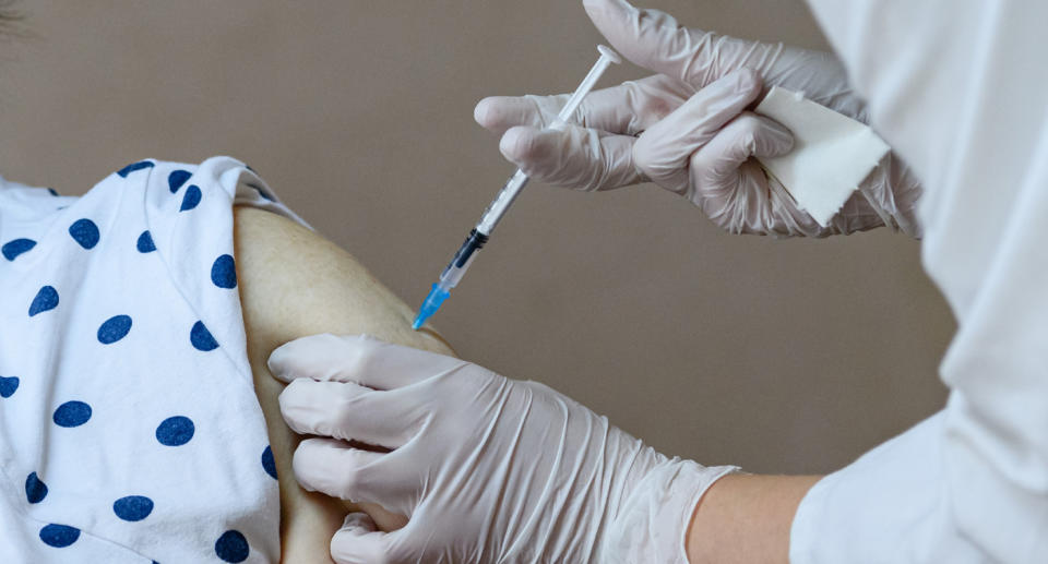 Arm being jabbed by a vaccine.