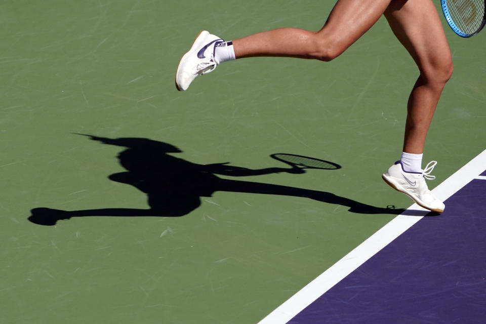 FILE - A women's professional tennis player casts a shadow while serving during the BNP Paribas Open tennis tournament Sunday, Oct. 17, 2021, in Indian Wells, Calif. The women’s professional tennis tour is increasing efforts to protect players from predatory coaches and others. (AP Photo/Mark J. Terrill, File)