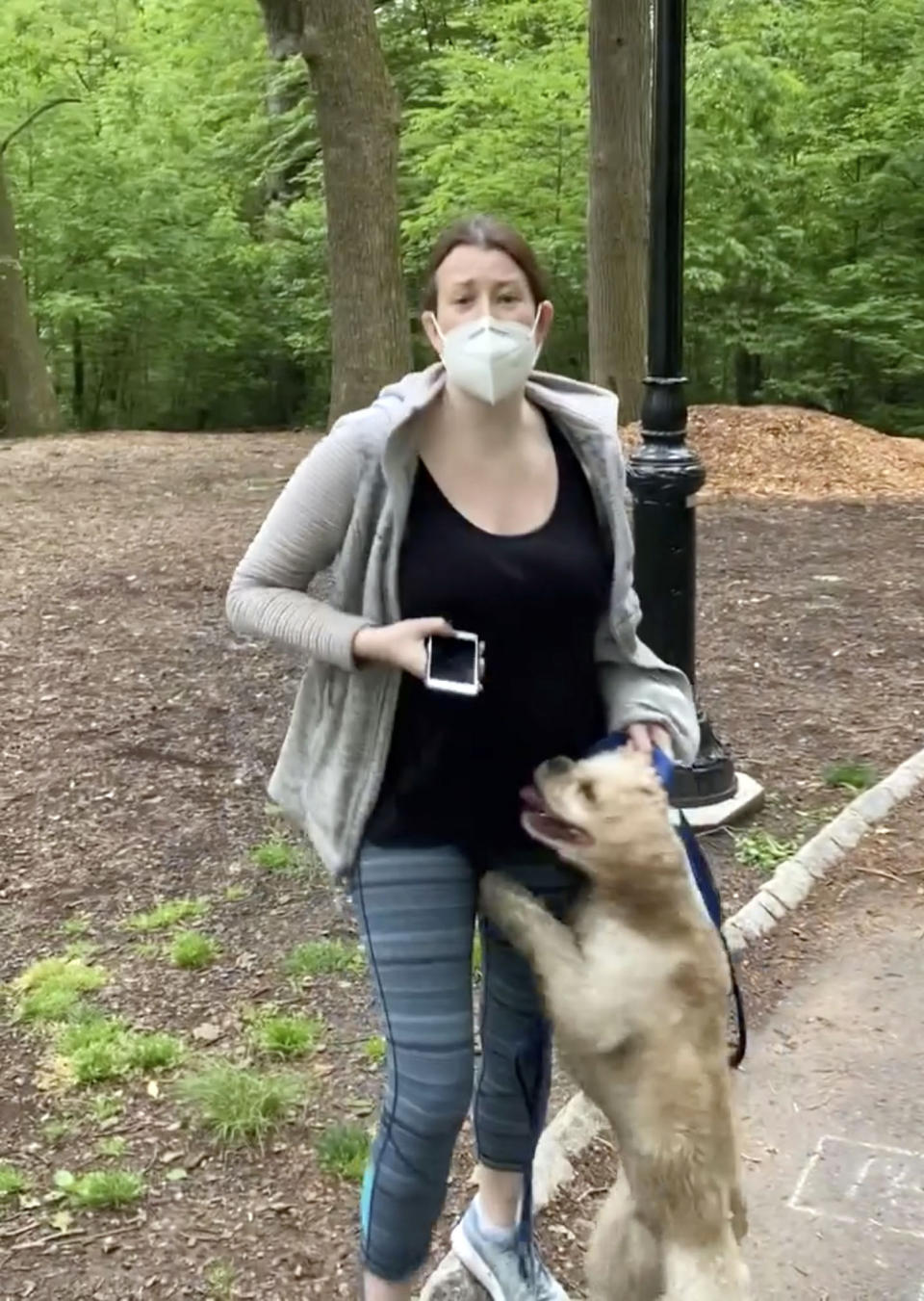 FILE — This image made from Monday, May 25, 2020, video provided by Christian Cooper shows Amy Cooper with her dog talking to Christian Cooper at Central Park in New York. Amy Cooper, the white woman who called 911 on Black birdwatcher Christian Cooper in New York's Central Park, is suing her former employer for firing her over the incident. (Christian Cooper via AP, File)