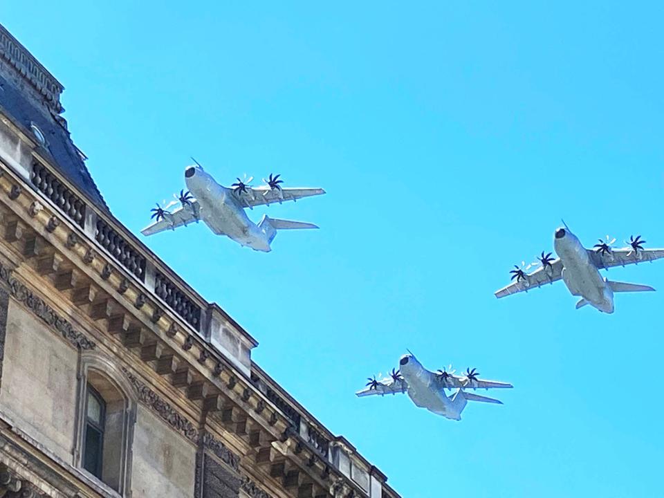 Military planes fly over the Louvre Museum in Paris practicing for Bastille Day the next day.