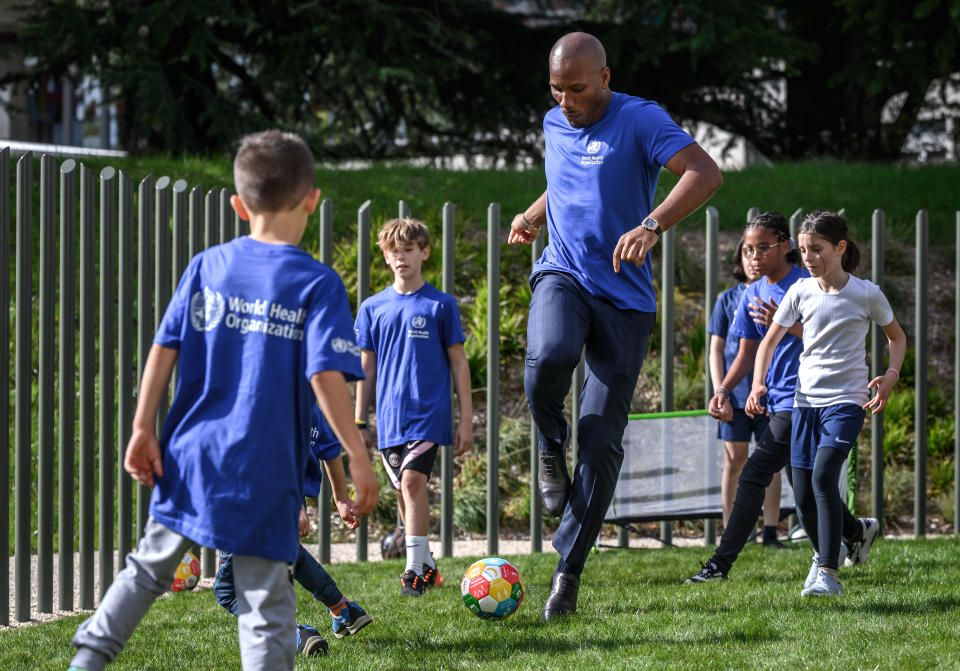 Football legend Didier Drogba plays with childs after being appointed as World Health Organization's Goodwill Ambassador for Sport and Health at the WHO headquarters in Geneva on Monday, October 18, 2021. A native of Ivory Coast, Drogba will help the WHO to promote its guidance on the benefits of physical activity and other healthy lifestyles, and communicate the value of sport, especially to young people. (Fabrice Coffrini/Keystone via AP)