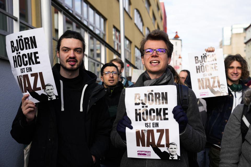 Protestor hold posters reading 'Bjoern Hoecke is a Nazi' outside the state court in Halle, Germany, Thursday, April 18, 2024. Bjoern Hoecke, goes on trial at the state court in Halle on charges related to his alleged use in a 2021 speech of a slogan used by the Nazis' SA stormtroopers. (AP Photo/Ebrahim Noroozi, Pool)