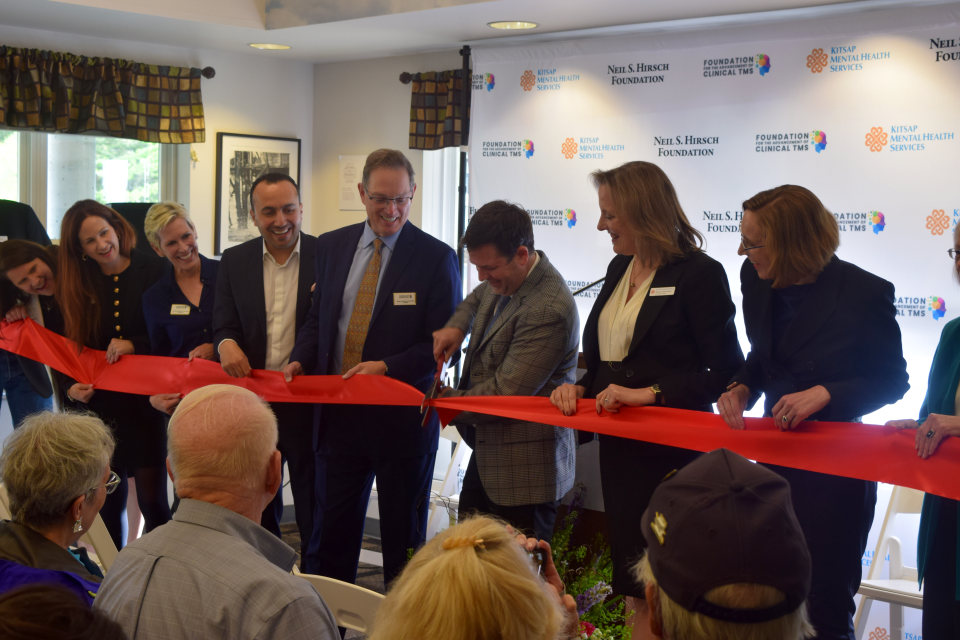 Kitsap Mental Health Services Chief Medical Officer James Hughes, center, cuts a ribbon to celebrate the opening of the Neil S. Hirsch TMS Clinic on May 16.