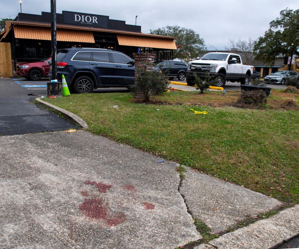 Blood stains and a small section of police tape show the scene where multiple people were injured following an overnight shooting at the Dior Bar & Lounge in Baton Rouge, La., on Sunday, Jan. 22, 2023.