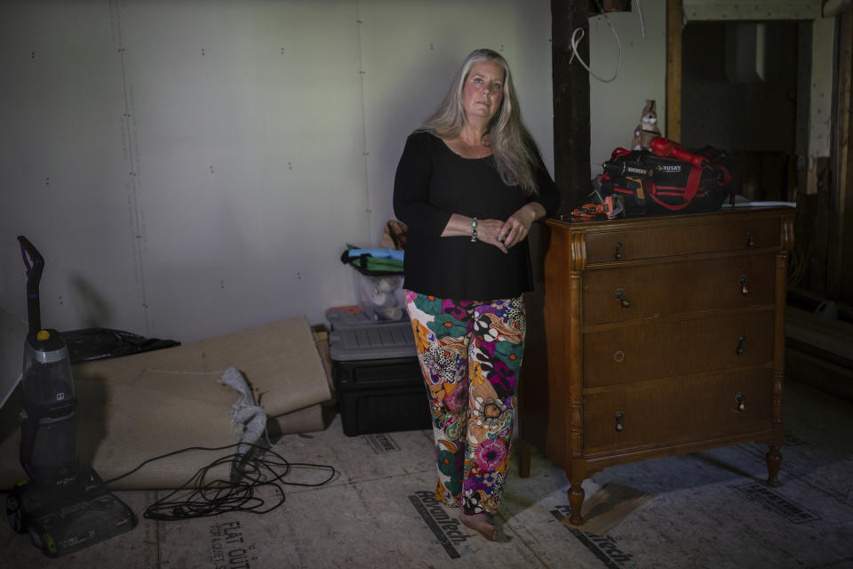 Lisa Edson-Neveu, 52 poses for a portrait at her house in Montpelier, Vt., July 3, 2024 that was damaged by the 2023 flood. A year after catastrophic flooding inundated parts of Vermont, some homeowners are still in the throes of recovery. (AP Photo/ Dmitry Belyakov)