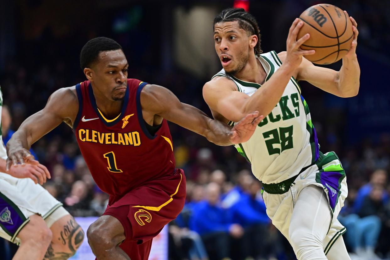 Milwaukee Bucks guard Lindell Wigginton drives on Cleveland Cavaliers guard Rajon Rondo in the first half of an NBA basketball game, Sunday, April 10, 2022, in Cleveland. (AP Photo/David Dermer)