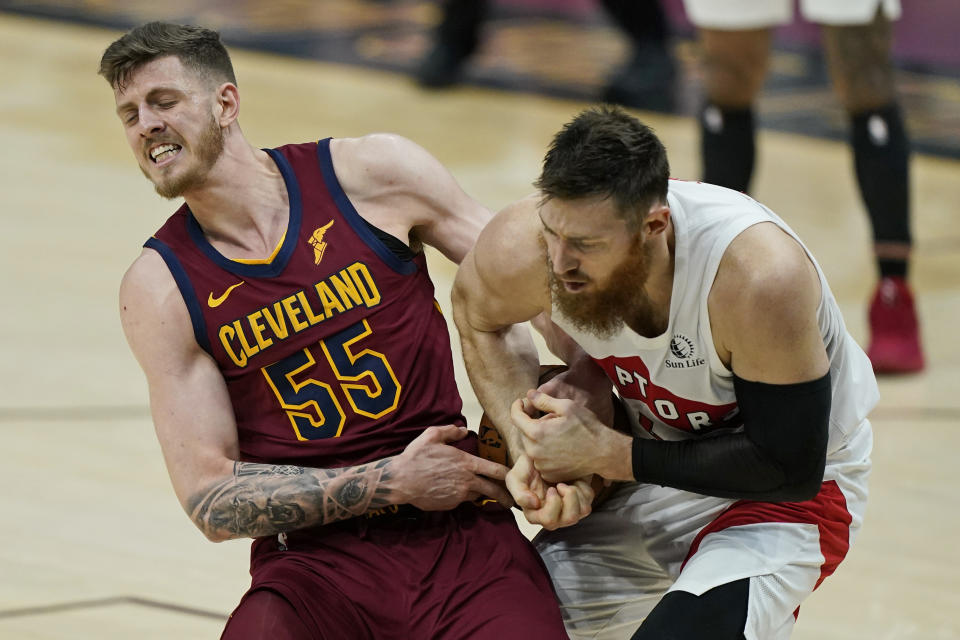 Cleveland Cavaliers Isaiah Hartenstein, left, and Toronto Raptors' Aron Baynes battle for the ball in the second half of an NBA basketball game, Saturday, April 10, 2021, in Cleveland. (AP Photo/Tony Dejak)