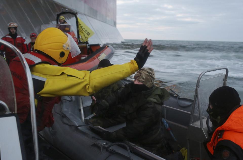 According to Greenpeace, a man identified as a Russian coast guard officer points a knife at a Greenpeace International activist, during a protest near a Gazprom oil platform in the Pechora Sea